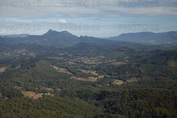 Clear blue sky with an open view across the valley toward Mount Warning (Wollumbin), captured from the summit of Mount Cougal, highlighting natural depth and wide landscape perspective, Queensland and New South Wales, Australia