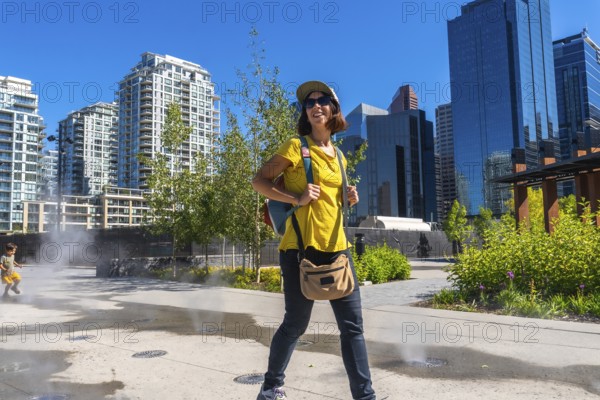 Female tourist exploring the vibrant east village neighborhood in calgary, enjoying the cityscape and summer weather during her urban adventure