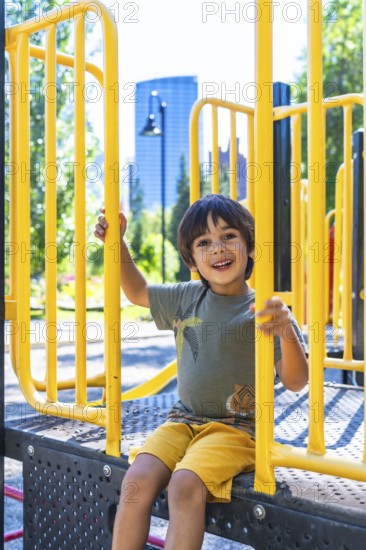 Happy child smiling and playing joyfully on a vibrant playground structure in calgary, canada, relishing the warmth of a sunny summer day outdoors in the park