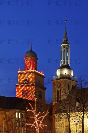 The Christmassy illuminated town hall tower and the illuminated church tower of St. John's Church in Witten, Ruhr area, North Rhine-Westphalia, Germany