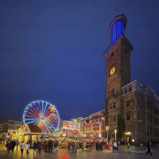 The town hall tower at the Christmas market with the Ferris wheel in the evening, Hagen, Ruhr area, North Rhine-Westphalia, Germany