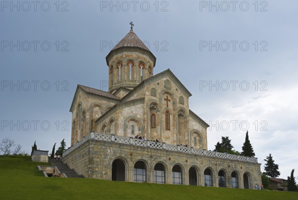 Stone church against a cloudy sky on a hill with strong architectural details, Bodbe monastery, Sighnaghi, Signagi, Kakheti province, Greater Caucasus, Georgia, Western Asia