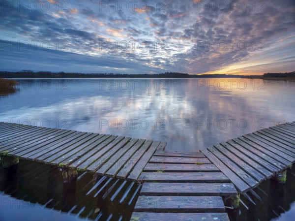 Evening at Schaalsee, wooden walkway with beautiful clouds in the sky at sunset, Schaalsee Biosphere Reserve, Mecklenburg-Western Pomerania, Germany