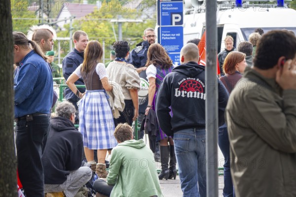 June 10, 2012 Demonstration in Göppingen, Baden-Württemberg, Germany. A Nazi and a punk and passers-by with police at the train station during a demonstration and illustrate the strong ideological conflict in public space