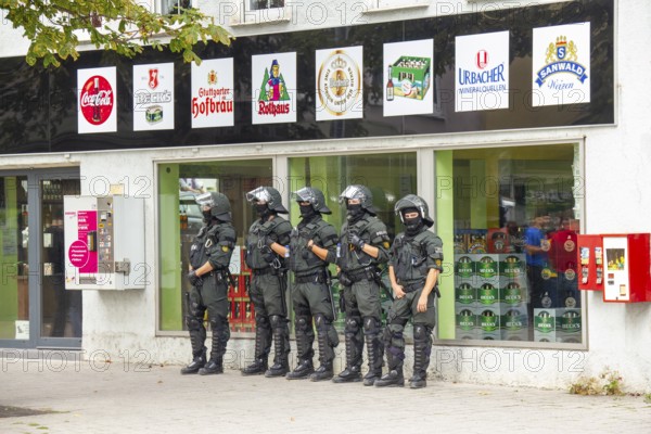 June 10, 2012 Demonstration in Göppingen, Baden-Württemberg, Germany. Riot police stand in a row in front of a beverage market and monitor what is happening during a demonstration in the urban area