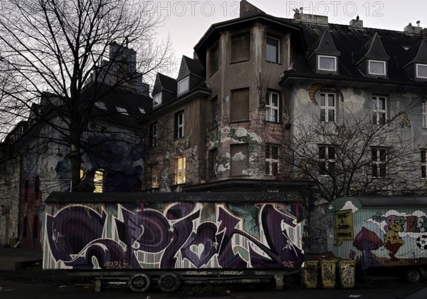 Kiefernstraße, residential street of the left-wing alternative scene with street art and construction trailer in the morning, Düsseldorf, North Rhine-Westphalia, Germany