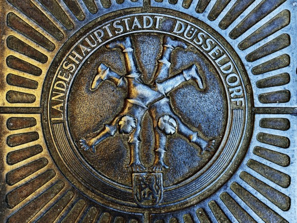 Manhole cover with classic depiction of the racket, landmark of the state capital Düsseldorf, North Rhine-Westphalia, Germany