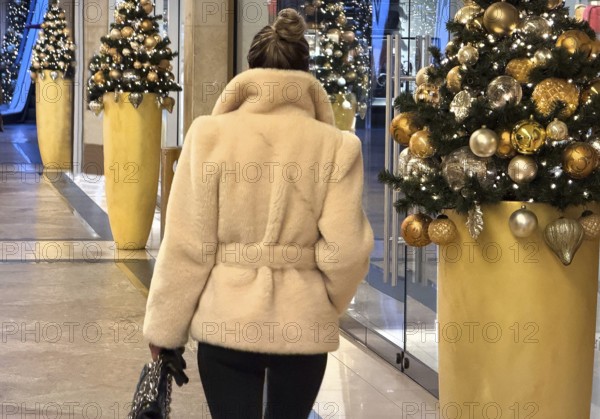 Luxuriously dressed woman in a Christmassy decorated passage in the KÖ Gallery, Düsseldorf, North Rhine-Westphalia, Germany