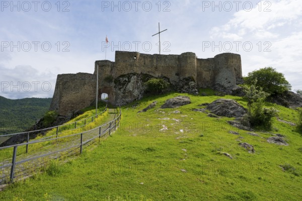 The picture shows medieval castle walls on a hill with surrounding nature under a cloudy sky, Kveshi Fortress, Bolnisi, Bolnissi, Lower Kartli region, Georgia
