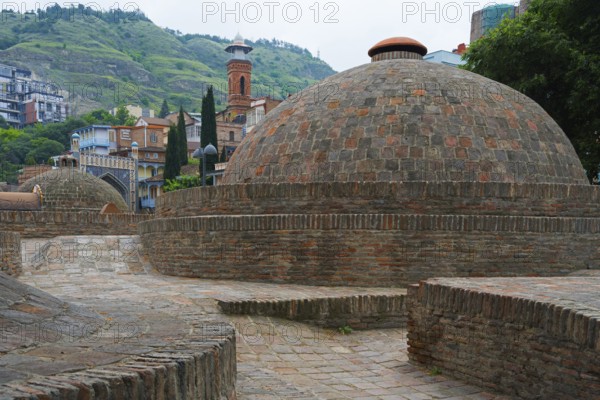 Traditional domes and brick buildings nestled in mountainous landscape, sulfur baths, Abanotubani spa district, old town, Tbilisi, Tbilisi, Georgia