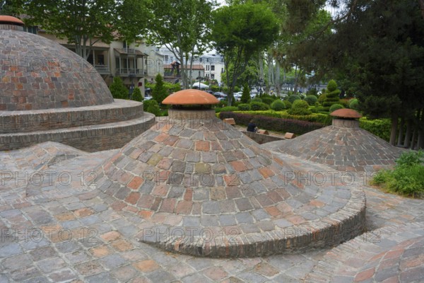 Dome formations and green surroundings with classic brick elements, sulfur baths, Abanotubani spa district, old town, Tbilisi, Tbilisi, Georgia