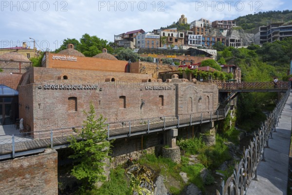 River valley with a brick bridge surrounded by historic architecture, King Erekles Bath, Abanotubani Spa District, Old Town, Tbilisi, Tbilisi, Georgia