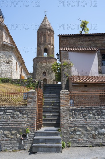 Old stone tower with adjacent building and stone stairs, sunny weather, St. George Church, Old Town, Sighnaghi, Signagi, Kakheti Province, Greater Caucasus, Georgia, Western Asia