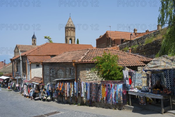 Market scene in an old paved town with colorful fabrics and historic buildings, old town, Sighnaghi, Signagi, Kakheti province, Greater Caucasus, Georgia, Western Asia