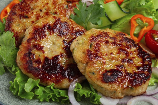 Fried chicken cutlets, minced chicken, with vegetables, on gray, with vegetable salad, top view, homemade, no people