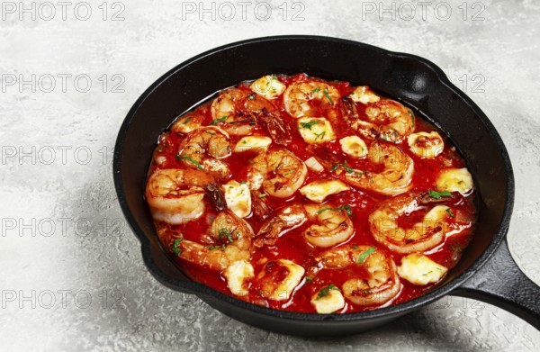 Greek saganaki, in an iron pan, saganaki with shrimp, shrimp in tomato sauce, with pepper and feta cheese, homemade, no people