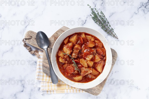 Meat goulash with potatoes and carrots, sweet peppers, in a saucepan, top view, traditional Hungarian soup, homemade, no people