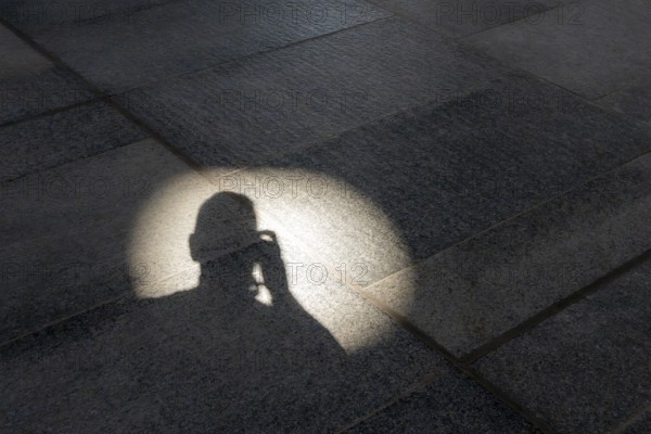 Head of a photographer in light on a stone floor, Abu Dhabi, United Arab Emirates