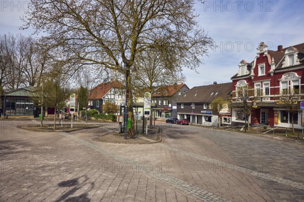 Niedersprockhövel church bus stop, bus platform, general architecture, houses, residential buildings and commercial buildings, bare winter trees, slightly diffused light, slightly sunny, milky blue sky, cumulus clouds, cirrostratus clouds, street main street, Sprockhövel, Ennepe-Ruhr district, North Rhine-Westphalia, Germany