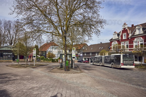 Niedersprockhövel church bus stop, bus platform, public architecture, houses, residential buildings and commercial buildings, bare winter trees, slightly diffused light, slightly sunny, milky blue sky, cumulus clouds, cirrostratus clouds, street main street, Sprockhövel, Ennepe-Ruhr district, North Rhine-Westphalia, Germany