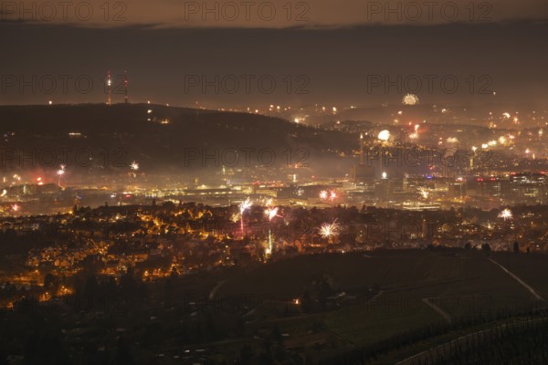 View from Kapellberg near Fellbach across the Neckar Valley to Stuttgart on New Year's Eve from 2025 to 2026. The television tower on the horizon as firecrackers and rockets light up the night sky at the turn of the year and greet the new year