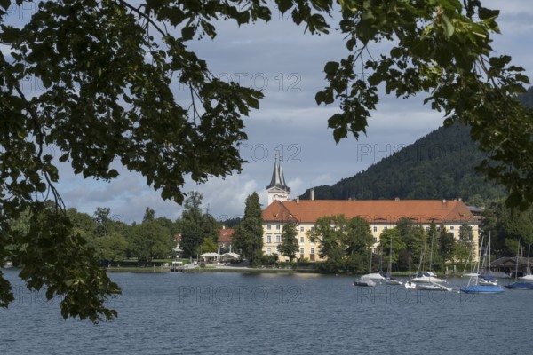 Parish Church of St. Quirinus, Tegernsee Abbey, Castle with Braustüberl, framed with branches, village Tegernsee, Upper Bavaria, Bavaria, Germany