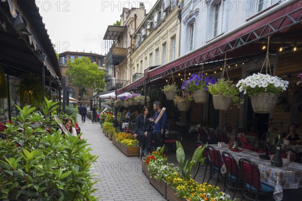 Lively street with outdoor cafés and colorful flowers along historic buildings, Old Town, Tbilisi, Tbilisi, Georgia