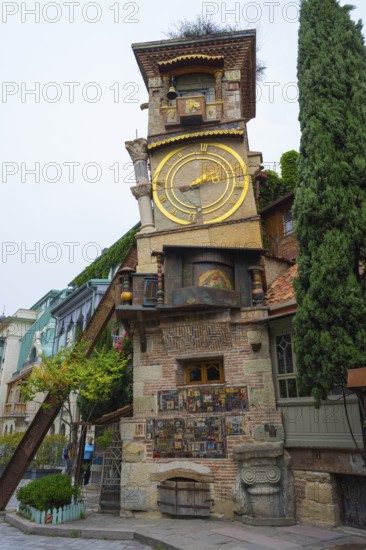 An old building with a big clock in a charming architectural style, surrounded by trees, clock tower, landmark for the State Puppet Theater, Tbilisi, Georgia