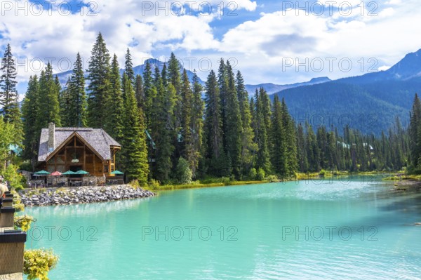 Emerald lake lodge, nestled among lush pine trees, reflects beautifully on the vibrant turquoise waters of emerald lake in yoho national park, british columbia
