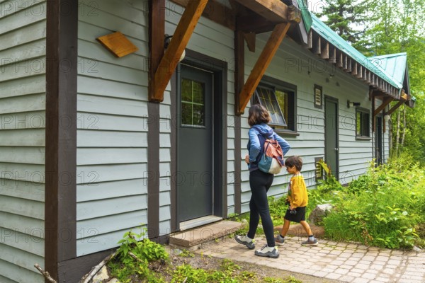 Mother and son leaving their cabin at emerald lake lodge, yoho national park, british columbia, canada, ready for a day of hiking and exploring the natural beauty of the canadian rockies