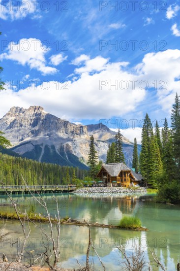 Emerald lake lodge reflecting on turquoise waters, framed by the canadian rockies and pine forest in yoho national park, british columbia, on a sunny summer day