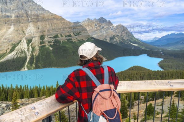 Young hiker admiring stunning turquoise color of peyto lake from viewpoint in banff national park, alberta, canada, during summer vacation enjoying breathtaking view of canadian rockies
