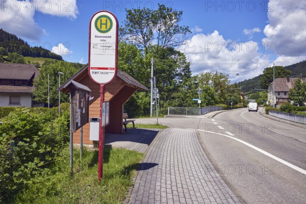 Simonswald Adler bus stop, bus shelters, road, sidewalk, car bridge and footbridge, metal railings, houses, hills, hilly landscape, coniferous forest, trees, pickup truck, blue sky, cumulus clouds, intersection An der Niederbruck, Am Martinshof and Untertalstraße, Simonswald, Black Forest, Emmendingen district, Baden-Württemberg, Germany