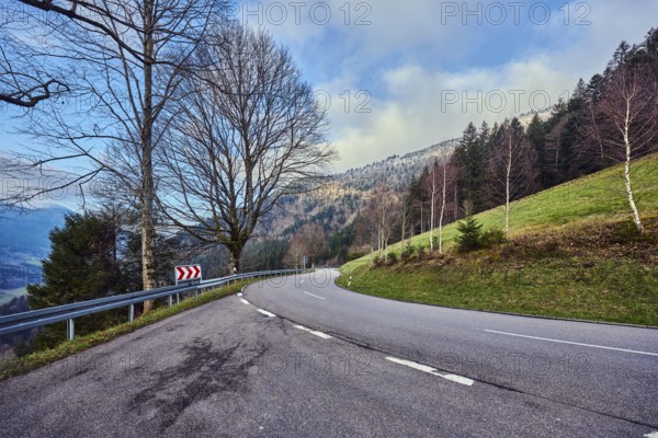 Simonswäldertal Dreitälerblick, hilly landscape, hill, road, center line, S-curve, coniferous forest, meadow, trees, bare winter trees, branches, haze, blue sky, cumulus clouds, country road L173, Simonswald, Black Forest, Emmendingen district, Baden-Württemberg, Germany