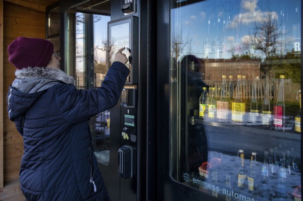 Elderly woman buying drinks, groceries at the vending machine, display, vending machine, shopping, typing, farm shop, winter, Mütze, Stuttgart, Baden-Württemberg, Germany