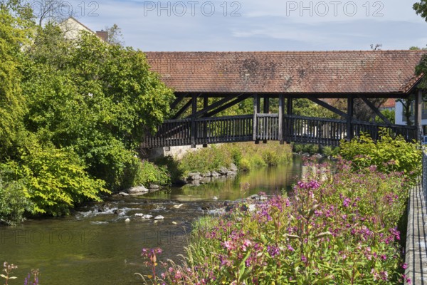 Covered footbridge over the Kronach river, hospital bridge, Blooming flowers on the shore, Kronach, Upper Franconia, Franconia, Bavaria, Germany