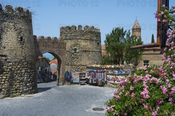 Historic stone gate with stalls and flowers in the foreground, city gate, entrance to the old town, Sighnaghi, Signagi, Kakheti province, Greater Caucasus, Georgia, Western Asia