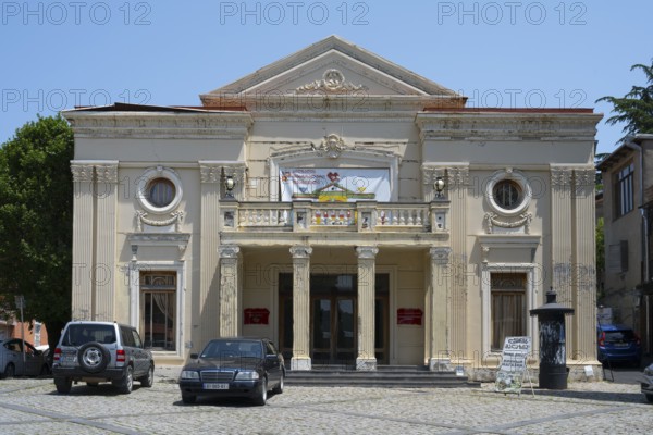 Neoclassical theatre building with columns and cars in the foreground on a sunny day, theatre, Sighnaghi, Signagi, Kakheti province, Greater Caucasus, Georgia, Western Asia