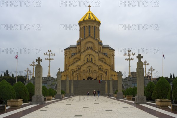 Grand cathedral with golden roof and stylish stone pillars against cloudy sky, Sameba Cathedral, Trinity Cathedral, Tbilisi, Tbilisi, Georgia