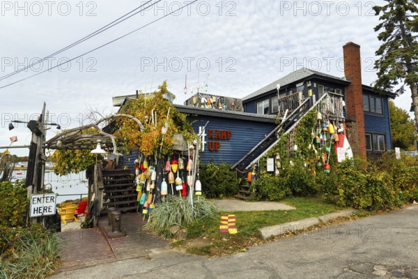 Colorful lobster buoys, decoration at former fishing lodge, seafood restaurant, lobster specialty, Perkins Cove, picturesque fishing village in Ogunquit, Maine, New England, USA