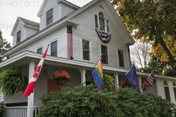Typical American house in autumn, white wooden house with veranda, guest room, rainbow flag, Canadian flag, Ogunquit, Maine, New England, USA