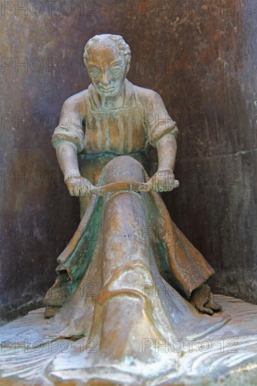 Tanner working with leather at Bonifatius Stirnberg's guild fountain 1983, modern art, bronze sculpture, city history, historical profession, craftsman, tannery, leather, fur, drawing iron, processing, manufacturing, tools, guild fountain, Reutlingen, Swabian Alb, Baden-Württemberg, Germany