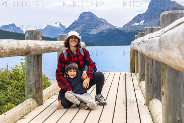 Tourists relishing the stunning scenery of bow lake in banff national park, alberta, canada, surrounded by majestic rocky mountains and enjoying a perfect summer day outdoors