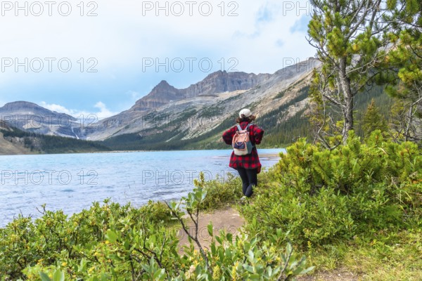 Female tourist enjoying the breathtaking view of bow lake and bow glacier in banff national park, embracing the tranquility of the canadian rockies in alberta, canada