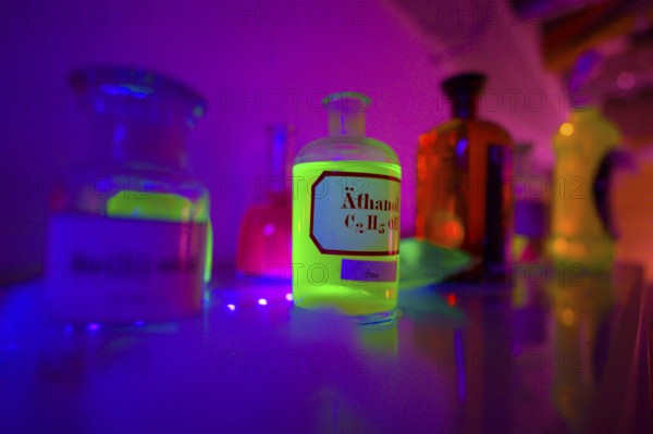 Glowing bottles in an escape room chemical laboratory with neon light create a mystical atmosphere, Lower Saxony, Germany