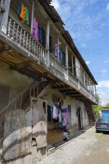 An old building with wooden balcony and clotheslines, next to it is an old car under a blue sky, traditional German house, Nikolaistraße 44, Bolnissi, Katharinenfeld, founded by Caucasian German settlers, Lower Kartli region, Kwemo Kartli, Georgia