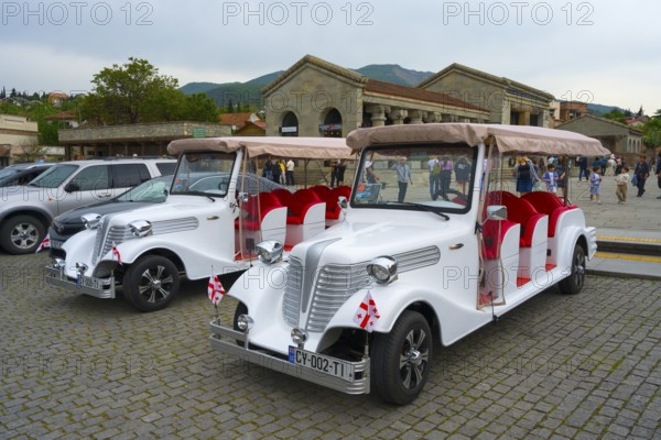 Nostalgic electric vehicles with Georgian flags for tourists in an old town, Mtskheta Square, Mtskheta, Mtskheta, Mtskheta, Mtskheta-Mtianeti region, Georgia