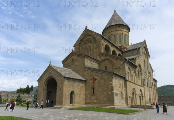 Impressive medieval stone cathedral with visitors under cloudy sky, Svetitskhoveli Cathedral, Svetitskhoveli, UNESCO World Heritage Site, Mtskheta, Mtskheta, Mtskheta-Mtianeti region, Georgia