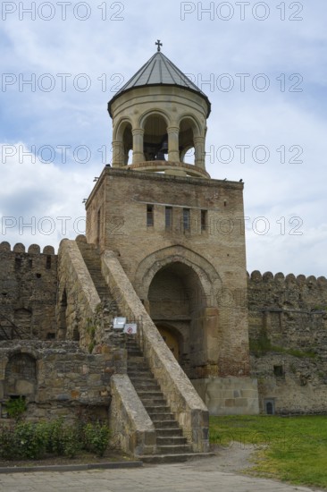 A bell tower with stone steps and fortress under a cloudy sky, Svetitskhoveli Cathedral, Svetitskhoveli, UNESCO World Heritage Site, Mtskheta, Mtskheta, Mtskheta-Mtianeti region, Georgia