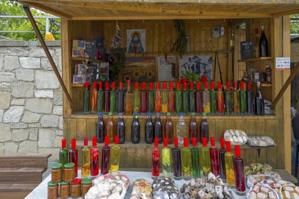 Market stall with various colorful bottles, food and souvenirs on a table, chacha with colorful fruits, vegetables or spices, pomace brandy, grape distillate, Mtskheta, Mtskheta, Mtskheta, Mtskheta-Mtianeti region, Georgia